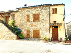 an old stone building with wooden doors and a staircase at Borgo San Savino in San Savino