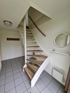 una escalera en una casa con espejo en De Rakken, en Woudsend