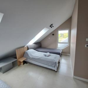 a bedroom with a bed and a window at Baltic Garden apartament dwupoziomowy 56 m² in Sztutowo