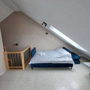 a bedroom with a bed and a crib in a attic at Baltic Garden apartament dwupoziomowy 56 m² in Sztutowo