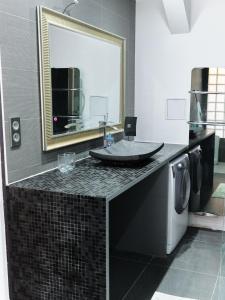 uma casa de banho com uma máquina de lavar roupa e um espelho. em Spacieux appartement aux portes de Paris, parking gratuit em Bagnolet