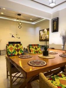 ein Esszimmer mit einem Holztisch und Stühlen in der Unterkunft Villa deux chambres in Cotonou