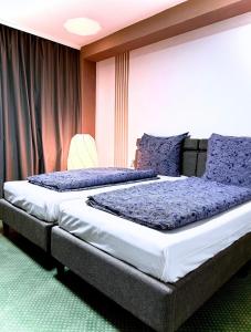 a bedroom with two beds with purple pillows at Hotel Hamburg Inn in Hamburg