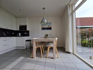 Woudsend的住宿－De Rakken，厨房配有桌椅和窗户。
