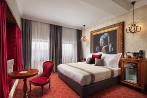 ブダペストにあるMystery Hotel Budapestのベッド、テーブル、椅子が備わるホテルルームです。