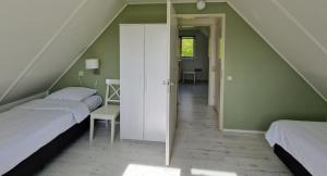 Woudsend的住宿－De Rakken，阁楼卧室设有两张床和楼梯。