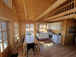 a large room with a wooden table and a kitchen at Geysir Cabins - Golden Circle Cabin only 800m from Geysir in Selfoss