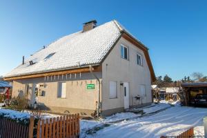 a house with a tin roof in the snow at Ferienwohnung Gustel in Freest