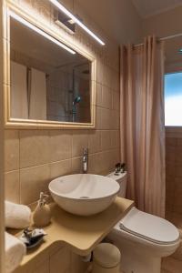 a bathroom with a sink and a toilet and a mirror at STUDIO SPYROS in Kanoni