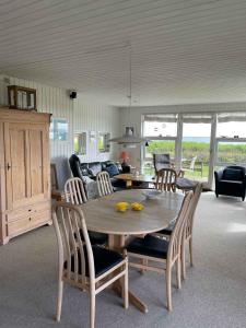sala de estar con mesa de madera y sillas en Summer House At Hvidbjerg Beach With Sea View en Børkop