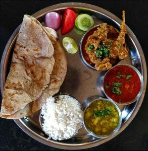 a silver plate with a plate of food with rice and curry at Munnar Mount Shelt Hotel in Munnar