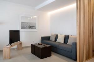 sala de estar con sofá azul y TV en Panasco Suites, en Arrecife