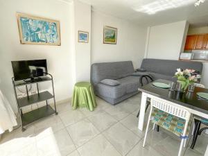 ein Wohnzimmer mit einem Sofa und einem Tisch in der Unterkunft Apartamentos Peñismar I-II 3000 in Peñíscola