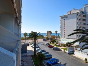 una strada cittadina con auto parcheggiate in un parcheggio di Apartamentos Peñismar I-II 3000 a Peñíscola