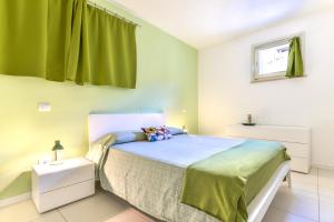 a bedroom with a bed and a green curtain at Lola in Capoliveri