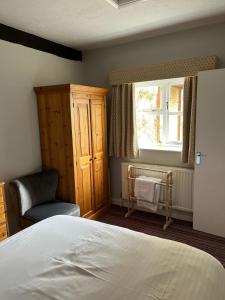 a bedroom with a bed and a chair and a window at Wellcroft in Buckinghamshire