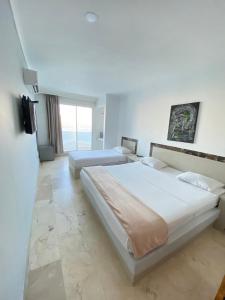 a bedroom with two beds and a large window at Hotel Cartagena Premium in Cartagena de Indias