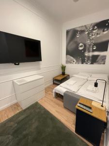 a bedroom with a large flat screen tv on a wall at SZIP Tatra Silver - Downtown in Budapest