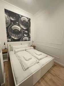 a white bed in a room with a painting on the wall at SZIP Tatra Silver - Downtown in Budapest