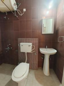 a bathroom with a toilet and a sink at Quality Hospitality Services in Pune