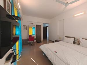 a bedroom with a bed and a desk with a television at Quality Hospitality Services in Pune