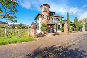 a house with a tower in the middle of a road at Ferienwohnung Weingut Löwenthal in Eschbach