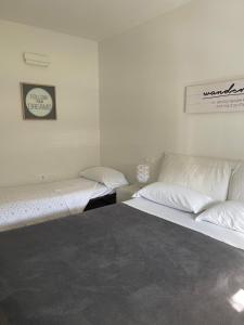 twee bedden in een kamer met witte muren bij Riva House in Riva del Garda