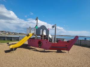 un parque infantil con un tobogán en la playa en Apelviken Lägenhetshotell, en Varberg