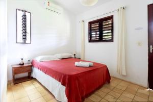 Habitación blanca con cama con manta roja en Pousada Área Talismã, en São Miguel do Gostoso