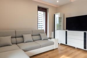 a living room with a couch and a flat screen tv at ROYAL Deluxe 2 rooms 6 persons Aquapark Down Town in Kraków