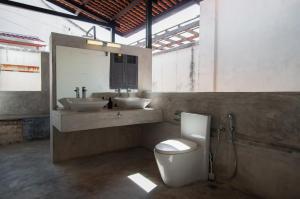 a bathroom with a toilet and a sink and a mirror at Aayu Stewart in George Town