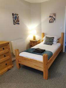 a bedroom with a wooden bed and a night stand at River Bay - Norfolk Broads in Brundall