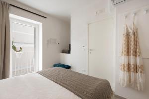 - une chambre blanche avec un lit et une fenêtre dans l'établissement WePuglia - Vista Cattedrale, à Monopoli
