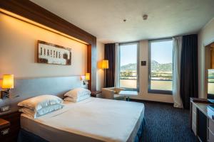 a hotel room with a bed and a large window at Delta Hotels by Marriott Olbia Sardinia in Olbia