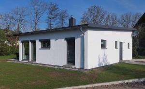 una pequeña casa blanca en un campo de hierba en Ferienhaus Casa Neugrua en Stockheim