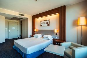 une chambre d'hôtel avec un lit et une chaise dans l'établissement Delta Hotels by Marriott Olbia Sardinia, à Olbia