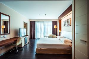 Cette chambre comprend un lit et un bureau. dans l'établissement Delta Hotels by Marriott Olbia Sardinia, à Olbia