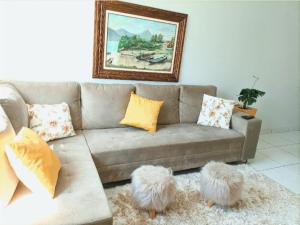 a living room with a couch with two furryoms in front at Casa com ar condicionado quente e frio in Paranavaí