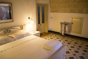 ナルドにあるB&B a Casa della Nonna Ucciaのベッドルーム1室(白いベッド1台、タオル付)
