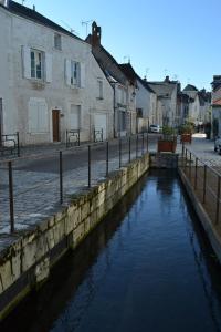 a canal in the middle of a street with houses at B&B chez Sylvain in Beaugency