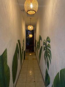 um corredor com plantas pintadas na parede em Nomades Hostel "The Apartment" em Panajachel