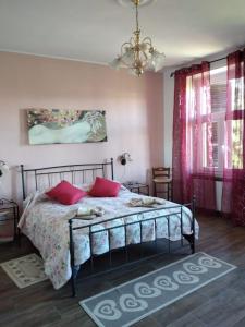 een slaapkamer met een bed met roze muren en een kroonluchter bij Patrizia Home in Zumaglia