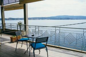 Ein Tisch und Stühle auf einem Balkon mit Blick auf das Wasser in der Unterkunft Drenia Studios in Amolianí