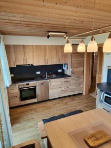 una cocina con electrodomésticos de acero inoxidable y armarios de madera en Schneiderhof Urlaub auf dem Bauernhof, en Bernau am Chiemsee