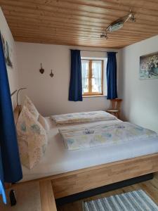 a bedroom with a bed with blue curtains at Schneiderhof Urlaub auf dem Bauernhof in Bernau am Chiemsee