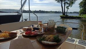 una mesa con dos platos de comida en un barco en Jacht motorowy Calipso 750, en Ryn
