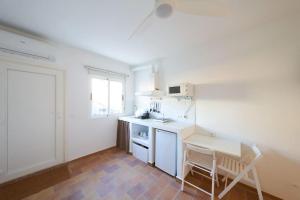 a white kitchen with a table and a chair in it at Lirondo in San José