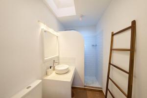 a white bathroom with a sink and a shower at Lirondo in San José +6 photos