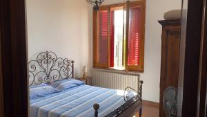 ガリポリにあるAttico Mimose Baia Verdeのベッドルーム1室(ベッド1台、赤いシャッター付きの窓付)