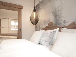 a bedroom with two white beds and a pendant light at Berg-Leben in Grossarl